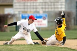 Two baseball players in action during a competitive game at an outdoor field.