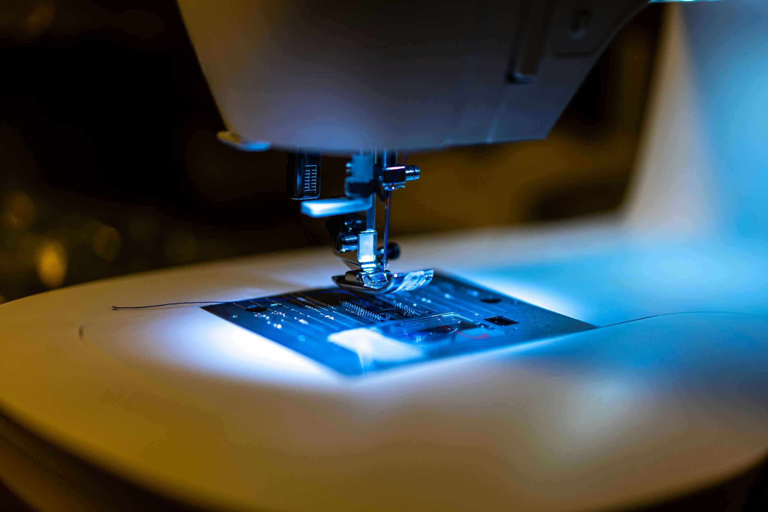 Detailed view of a sewing machine's needle area with LED lighting, highlighting modern technology.